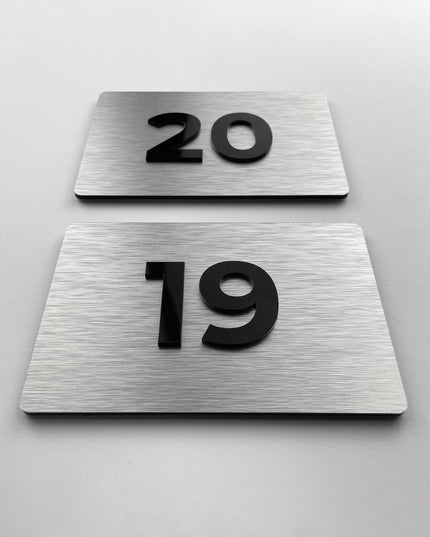 Brushed silver room number sign for doors by ALUMADESIGNCO featuring metal plaque and acrylic numbers, modern door signage for hotel rooms and apartment interiors