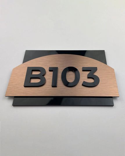 Apartment door identification plaque with a brushed bronze finish and acrylic numbers