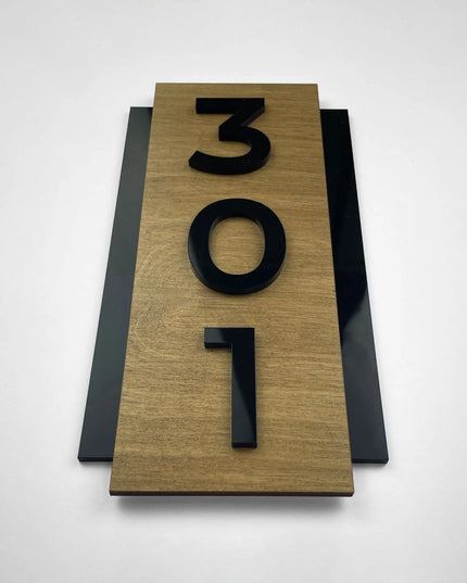 Personalisiertes Hotel-Türschild im Hochformat mit Holzgrundplatte und individueller Zimmernummer aus schwarzem Acryl für moderne Innenräume.