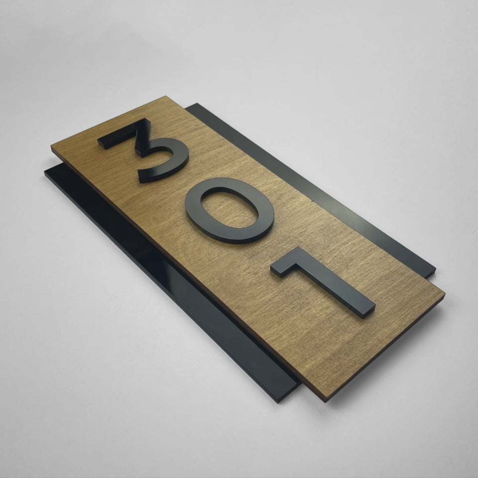 Modern vertical hotel room number sign by ALUMADESIGNCO combining birch plywood and black acrylic numbers, stylish wood door plaque for hotel hallways, offices, and luxury apartments